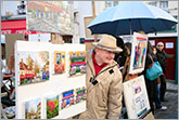 Photo of artist showing pictures at Montmartre in Paris
